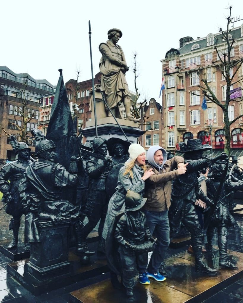 A picture of Kate and her husband in Amsterdam with some statues.